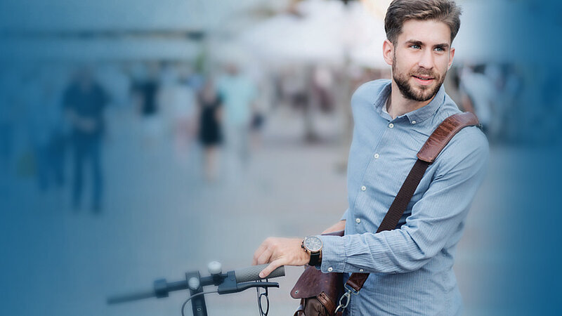 Ein Mann der sein Fahrrad schiebt